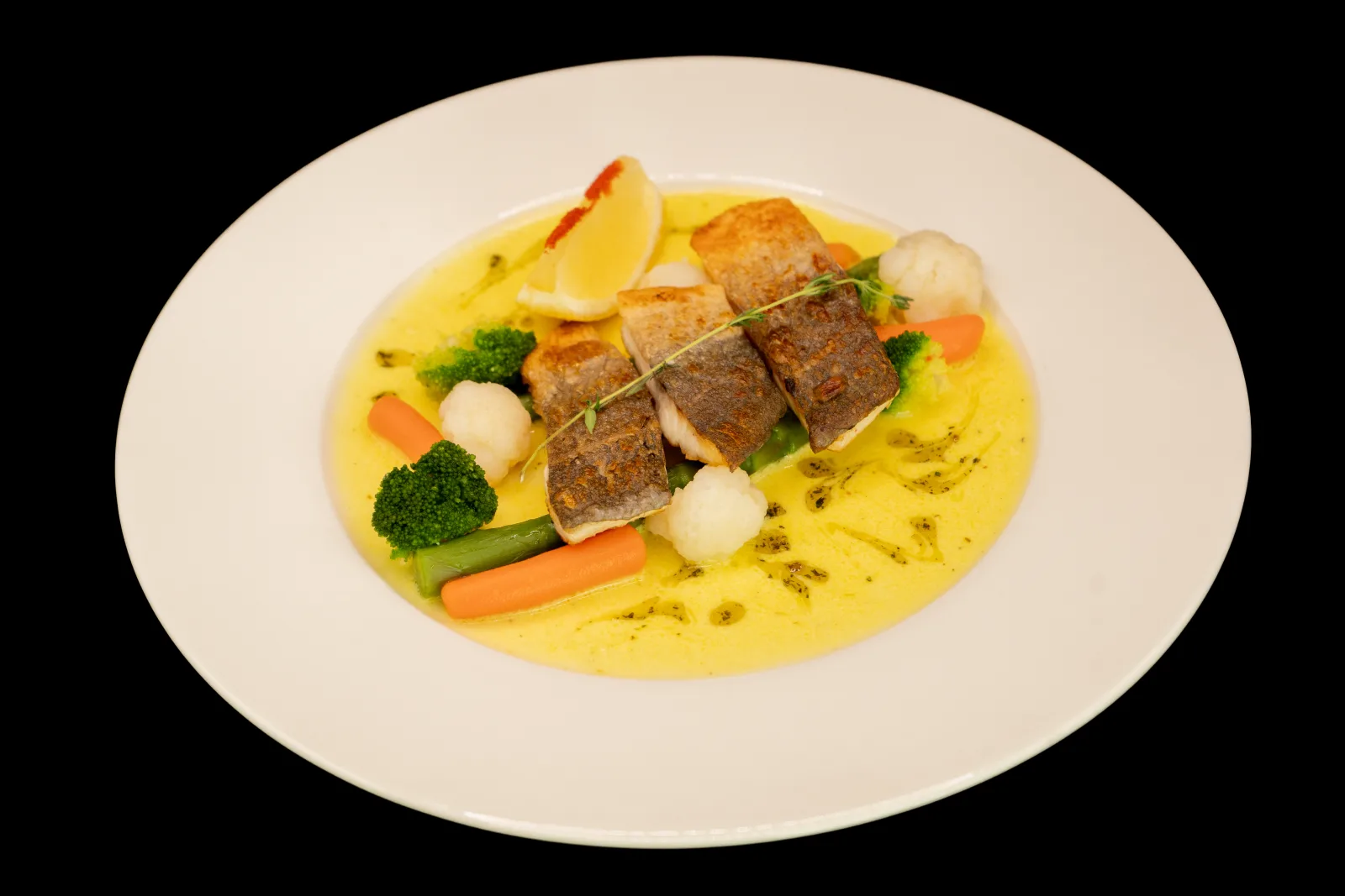 Sea bream fillet with vegetable garnish and lemon sauce from the menu of Restaurant Europe Merul